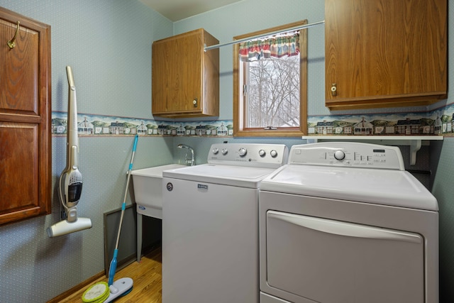 laundry room featuring cabinets, sink, and washer and clothes dryer