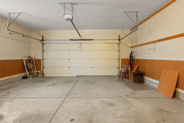 garage with a garage door opener and wood walls