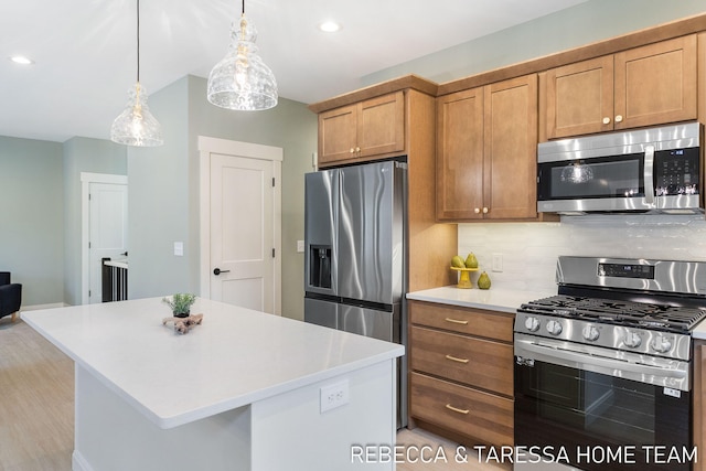 kitchen featuring stainless steel appliances, a center island, pendant lighting, and decorative backsplash