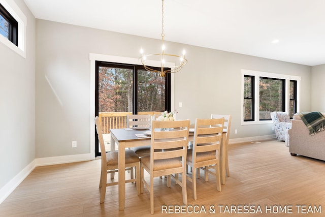 dining space featuring a notable chandelier, light hardwood / wood-style flooring, and a wealth of natural light