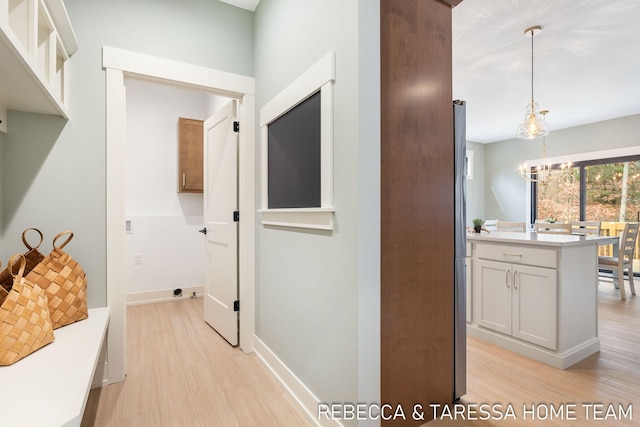 mudroom featuring a chandelier and light hardwood / wood-style floors