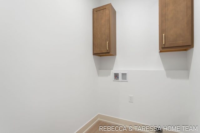 laundry area featuring hardwood / wood-style floors, hookup for a washing machine, and cabinets