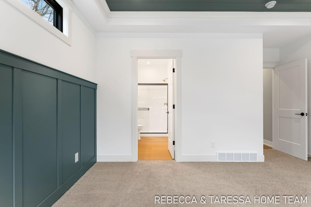 unfurnished bedroom featuring carpet floors and connected bathroom