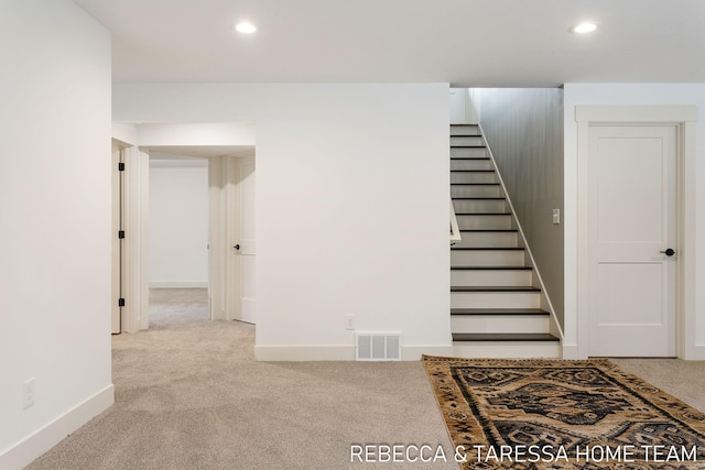 staircase featuring carpet