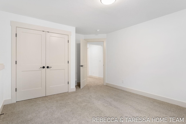 unfurnished bedroom featuring light colored carpet and a closet