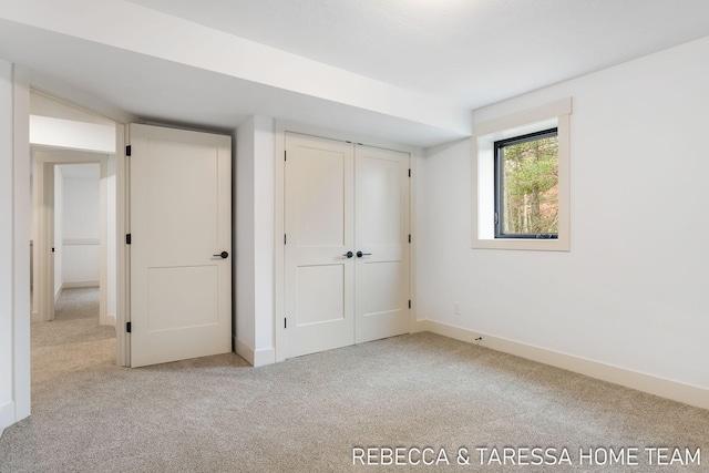 unfurnished bedroom with light colored carpet and a closet