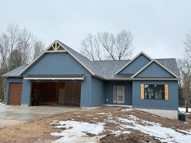 view of front of property with a garage, concrete driveway, and roof with shingles