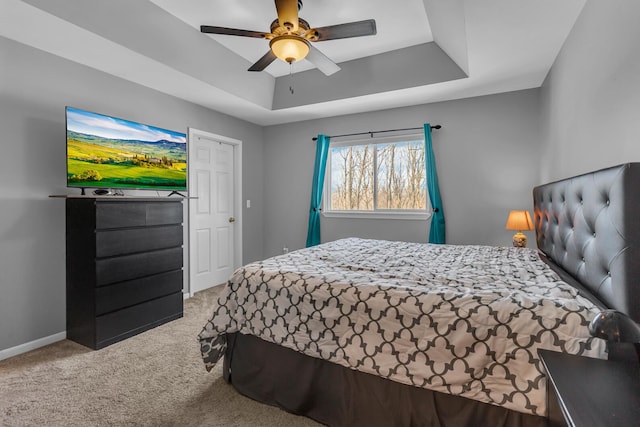 bedroom featuring ceiling fan, carpet flooring, and a raised ceiling