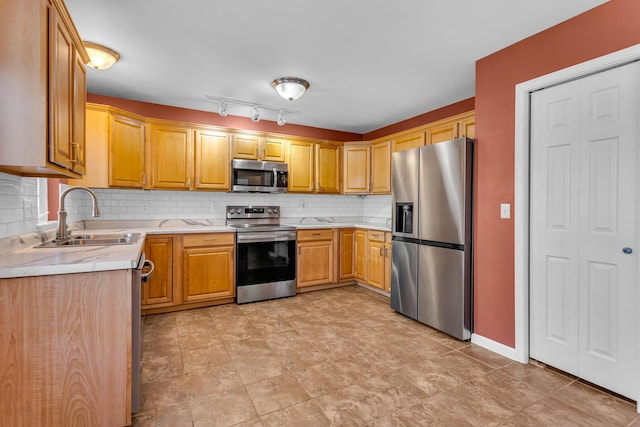 kitchen featuring stainless steel appliances, tasteful backsplash, and sink