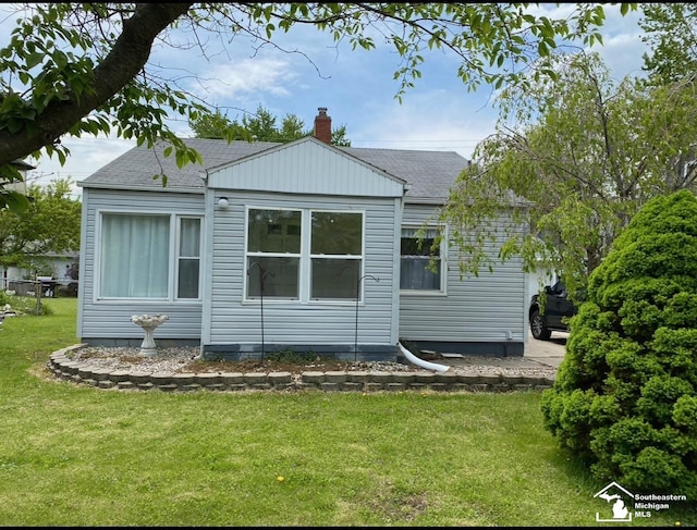 back of house featuring a lawn