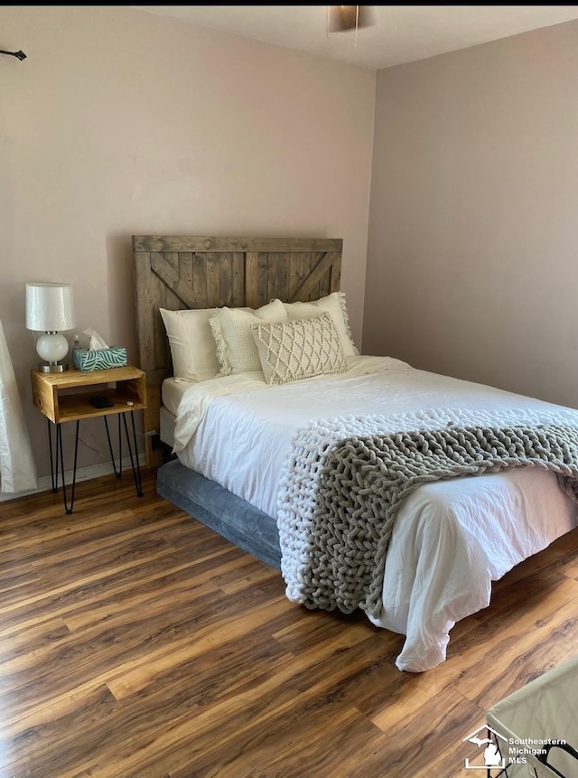 bedroom with ceiling fan and dark hardwood / wood-style floors