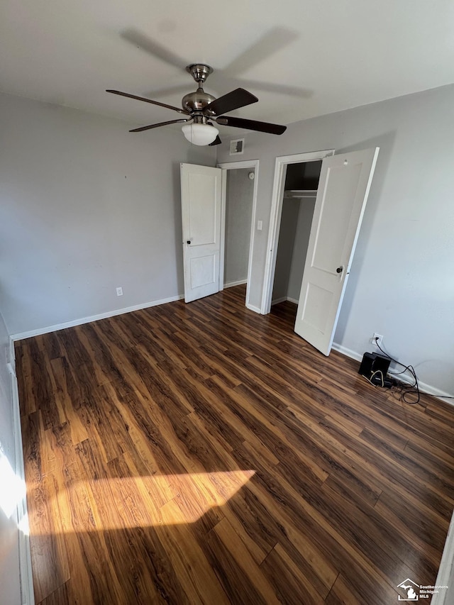 unfurnished bedroom with ceiling fan, a closet, and dark hardwood / wood-style floors