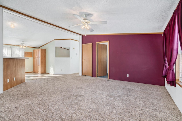 empty room featuring ceiling fan, light colored carpet, a textured ceiling, and lofted ceiling