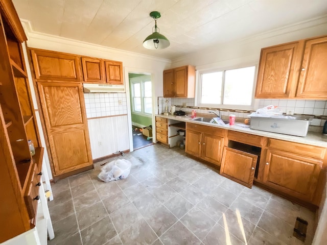 kitchen with crown molding, decorative backsplash, sink, and decorative light fixtures