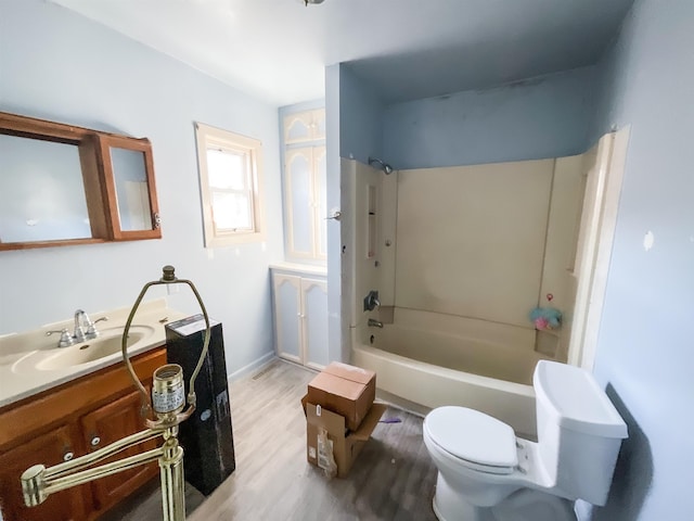 full bathroom featuring hardwood / wood-style floors, washtub / shower combination, vanity, and toilet