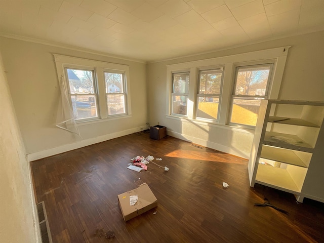 empty room featuring dark hardwood / wood-style floors and crown molding