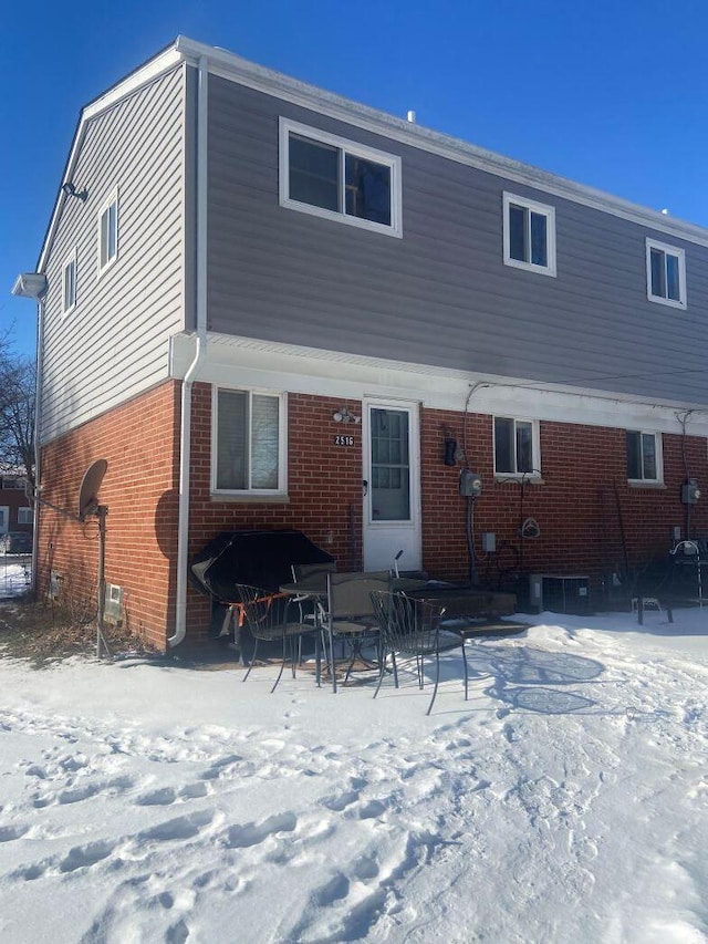 view of snow covered rear of property