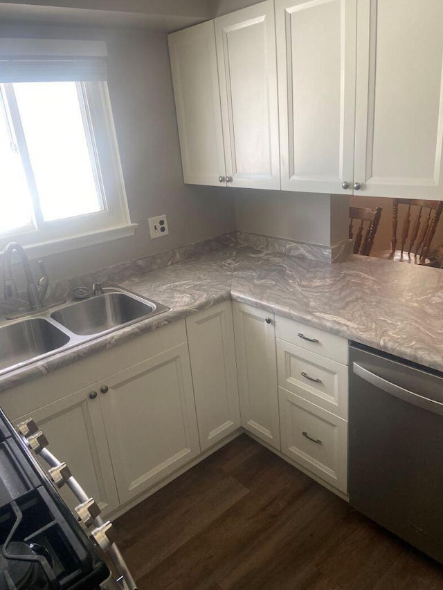 kitchen featuring stainless steel dishwasher, dark hardwood / wood-style floors, sink, and white cabinets