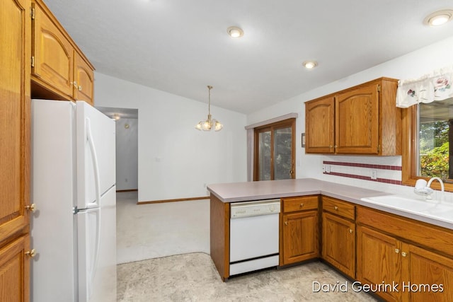 kitchen featuring kitchen peninsula, a notable chandelier, white appliances, pendant lighting, and sink