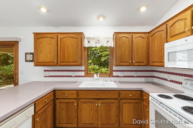 kitchen featuring decorative backsplash, sink, and white appliances