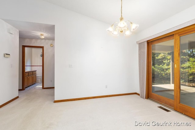 carpeted empty room with a notable chandelier