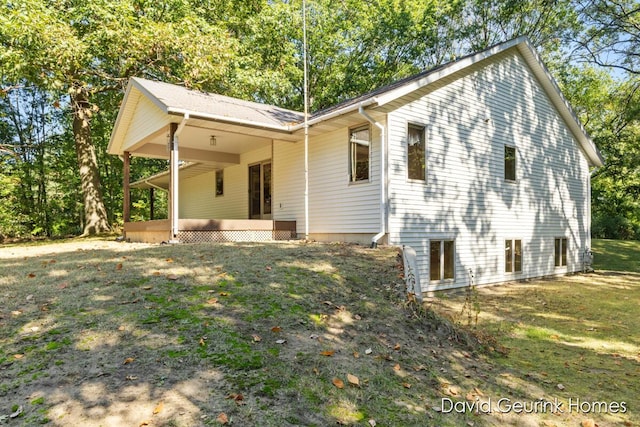 back of property with a yard and a porch