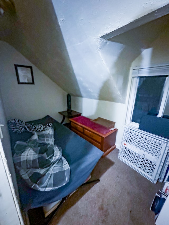 carpeted bedroom with lofted ceiling