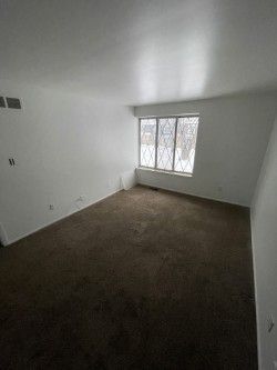 spare room with dark colored carpet