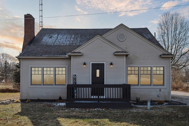 view of front of house featuring a wooden deck and a lawn