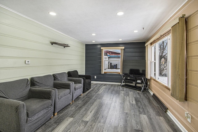 living room with dark hardwood / wood-style flooring, ornamental molding, and a textured ceiling