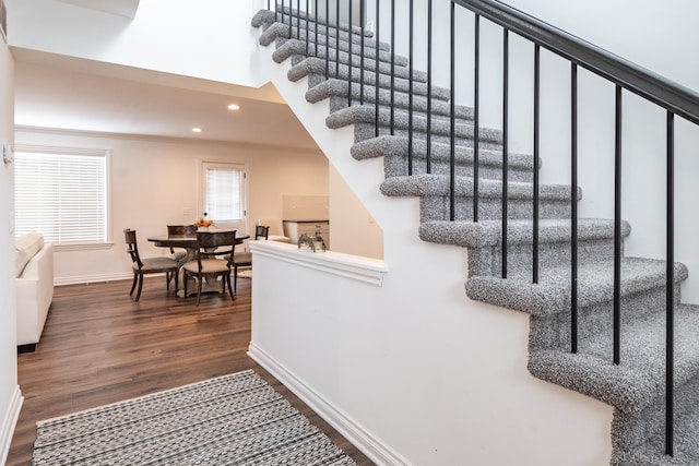 stairs with hardwood / wood-style flooring and crown molding