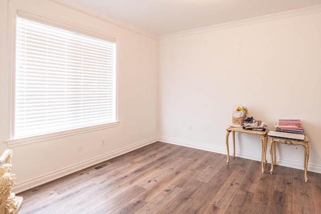 unfurnished room featuring wood-type flooring, ornamental molding, and a wealth of natural light