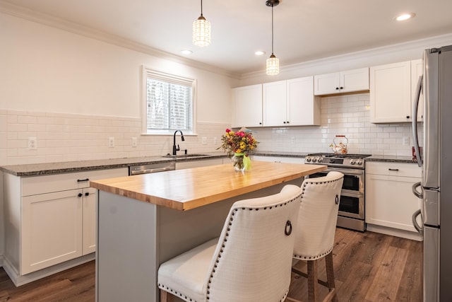 kitchen with a kitchen breakfast bar, a center island, stainless steel appliances, and wood counters