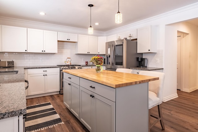 kitchen featuring pendant lighting, white cabinets, stainless steel appliances, and a kitchen island