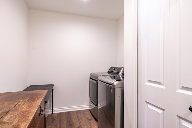 clothes washing area with dark hardwood / wood-style floors and washer and dryer