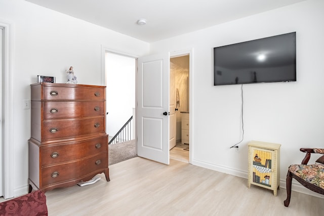 bedroom with light wood-type flooring and connected bathroom