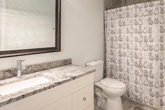 bathroom featuring wood-type flooring, curtained shower, toilet, and vanity