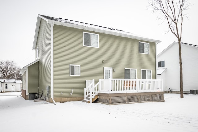 snow covered rear of property with central air condition unit and a wooden deck