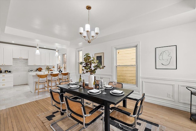 dining area with a notable chandelier and light hardwood / wood-style flooring