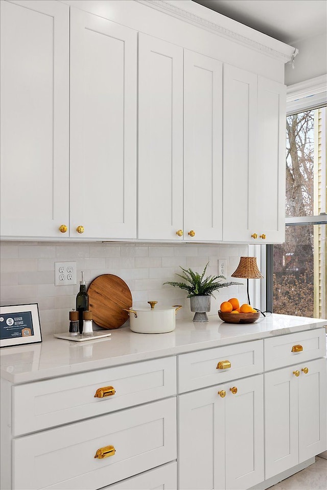 kitchen with tasteful backsplash and white cabinets