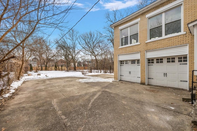 view of snowy exterior with a garage