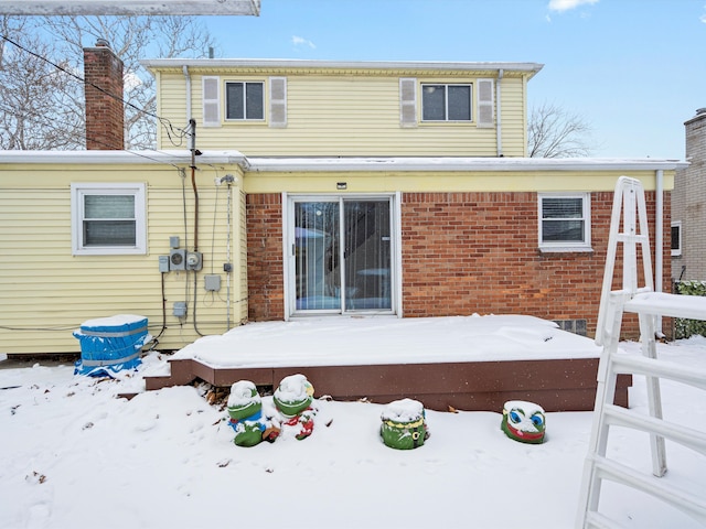 snow covered rear of property featuring a wooden deck