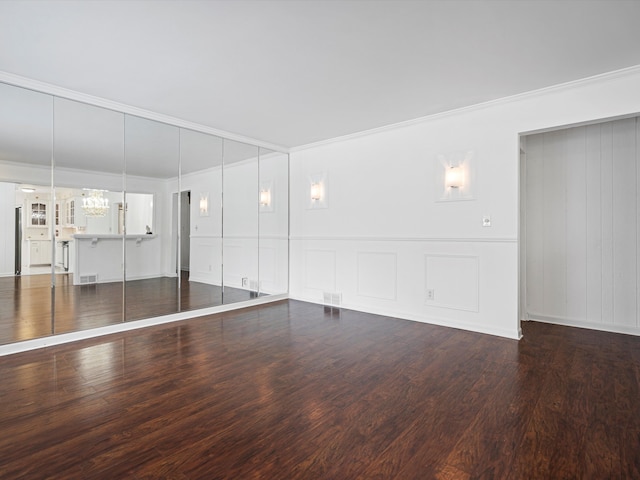 empty room with dark wood-type flooring and ornamental molding