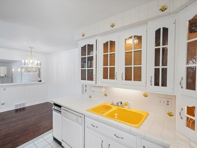 kitchen with white cabinets, dishwasher, decorative light fixtures, sink, and tile countertops