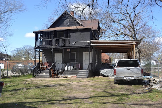 2908 Hoyt St, Muskegon Heights, MI 49444 - view of front facade featuring a porch, a chimney, fence, a shingled roof, and an attached carport
