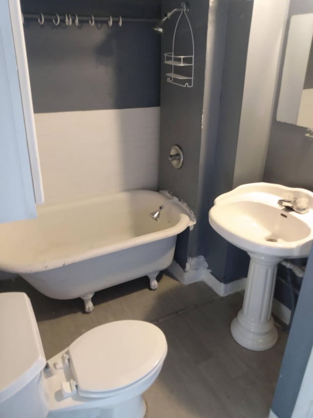 2908 Hoyt St, Muskegon Heights, MI 49444 - bathroom featuring a tub to relax in, toilet, and wood finished floors