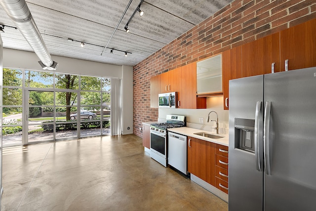 kitchen with brick wall, stainless steel appliances, and sink