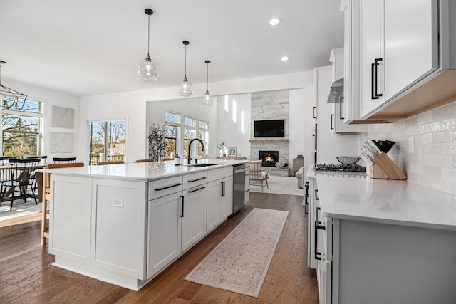 kitchen featuring white cabinetry, pendant lighting, a kitchen island with sink, and sink