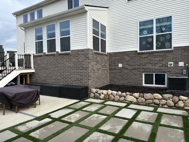 view of side of home featuring cooling unit and a patio area