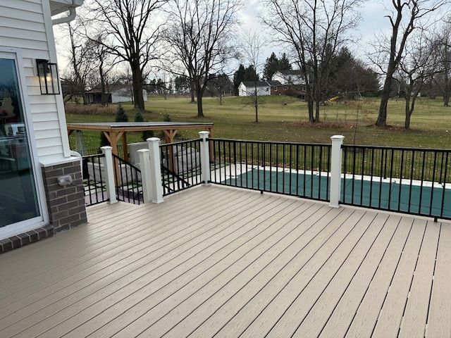 wooden deck with a covered pool and a yard